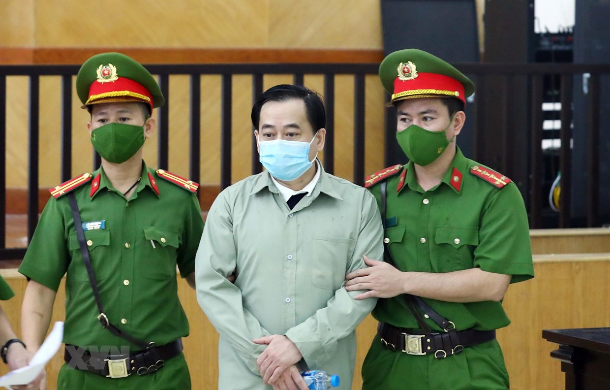 Lực lượng chức năng dẫn giải bị cáo Phan Văn Anh Vũ đến phiên tòa xét xử. 