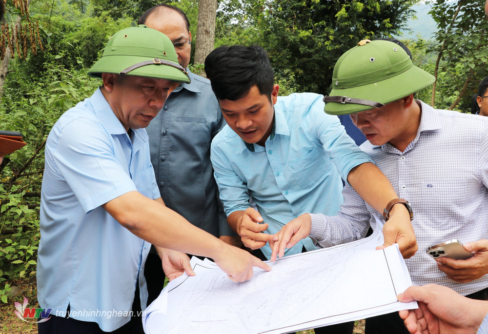 Phó Chủ tịch UBND tỉnh Nguyễn Văn Đệ xem sơ đồ khu tái định cư tại bản Cầu Tám, xã Tà Cạ. 