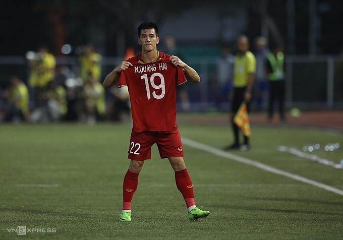 Tiến Linh giơ cao áo của Quang Hải - cầu thủ không thể thi đấu vì chấn thương - sau khi ghi bàn thứ hai cho Việt Nam. Ảnh: VNE