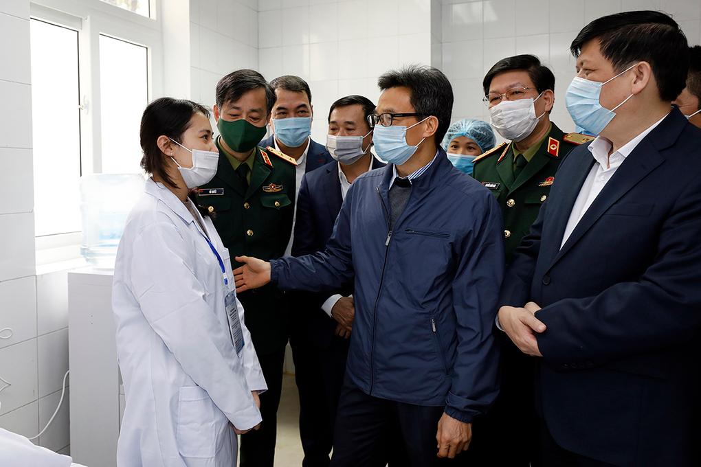 Phó thủ tướng Vũ Đức Đam động viên một trong ba tình nguyện viên đầu tiên tiêm thử nghiệm vaccine Covid-19 do Việt Nam sản xuất. Ảnh: VGP