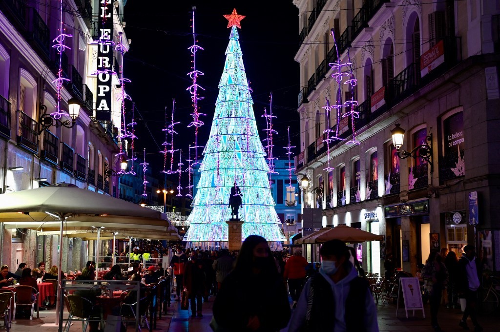 Người dân đeo khẩu trang, đi dạo trên con phố rực ánh đèn trang trí Giáng sinh ở Madrid, Tây Ban Nha, ngày 22/12.