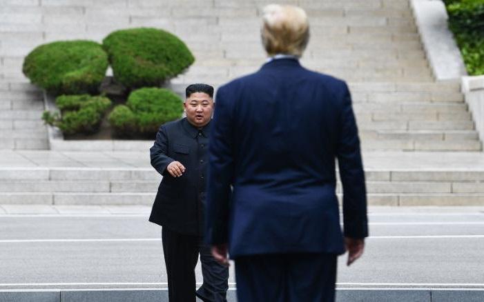 Chủ tịch Kim Jong-un và Tổng thống Mỹ Donald Trump đối diện nhau giữa làng đình chiến Bàn Môn Điếm ở khu phi quân sự liên Triều vào hôm 30/6/2019. Ảnh: Getty.